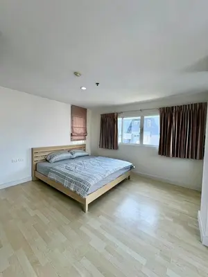 a bedroom with a bed and two windows at City Living condo at BKK in Bangkok