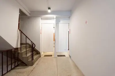 a hallway with a door and stairs in a building at xx Mitr Inn Khaosan - มิตร อินน์ ข้าวสาร in Bangkok