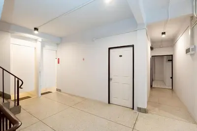 an empty hallway with a white door and stairs at xx Mitr Inn Khaosan - มิตร อินน์ ข้าวสาร in Bangkok