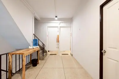 a hallway with a wooden table and a door at xx Mitr Inn Khaosan - มิตร อินน์ ข้าวสาร in Bangkok