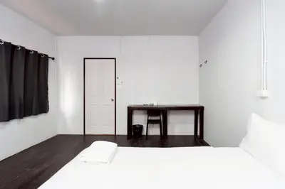 a white room with a bed and a table at xx Mitr Inn Khaosan - มิตร อินน์ ข้าวสาร in Bangkok