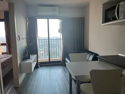 a hotel room with a table and a balcony at Convenient 1 bed condo Hua Mak in Sathani Ban Hua Mak