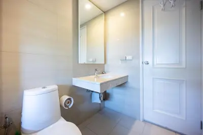 a bathroom with a sink and a toilet and a mirror at Beautiful 1 bed with huge Lumpini park view in Bangkok