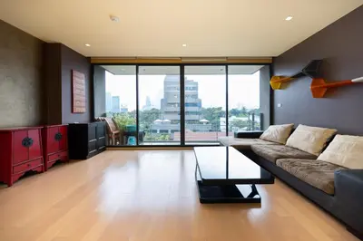 a living room with a couch and a table at Beautiful 1 bed with huge Lumpini park view in Bangkok
