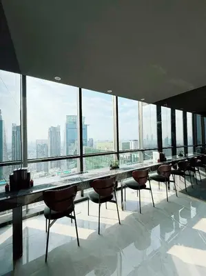 a large room with tables and chairs in a building with windows at Brand New CONDO near Siam Paragon in Pratunam