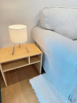 a bed and a table with a lamp on it at Brand New CONDO near Siam Paragon in Pratunam