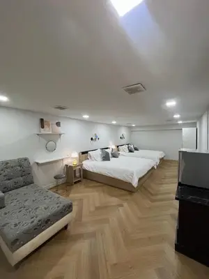 a bedroom with two beds and a couch in it at Huai Khwang Townhome in Ban Na Song