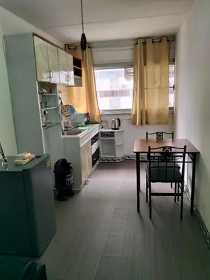 a small kitchen with a table and a refrigerator at อิมแพ็ค คอนโดเมืองทอง in Thung Si Kan