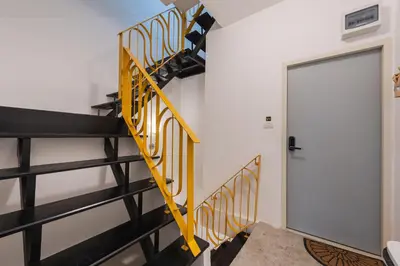 a yellow and black spiral staircase in a room with a door at Studio Kunst in Bangkok