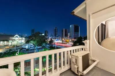 a balcony with a view of the city at night at Studio Kunst in Bangkok