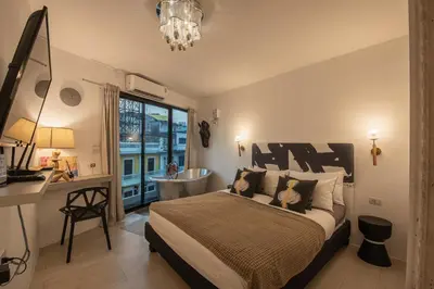 a bedroom with a bed and a desk and a window at Studio Kunst in Bangkok