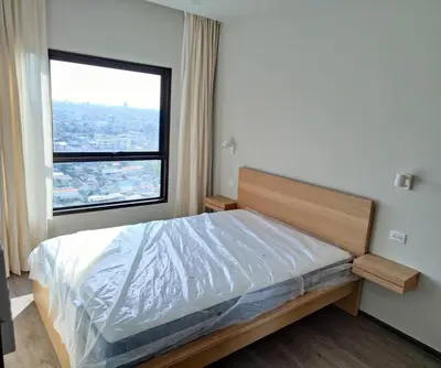 a bedroom with a bed with a large window at Apartment in Thon Buri 0 meter From BTS station in Bang Khun Thian
