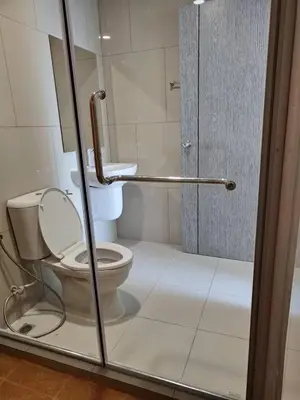 a bathroom with a toilet and a glass shower door at Apartment in Thon Buri 0 meter From BTS station in Bang Khun Thian