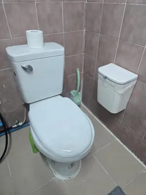 a bathroom with a toilet and a trash can at 103 Lovely AC apartment with private kitchen in Bangkok