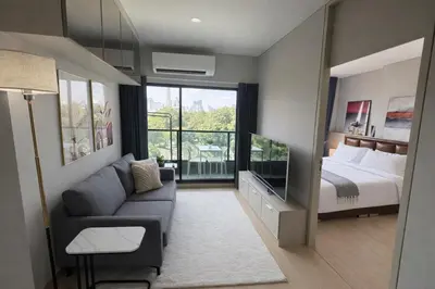 a living room with a couch and a bed at 2BR Modern Condo Office Room Sofa Bed Pool Gym in Bangkok