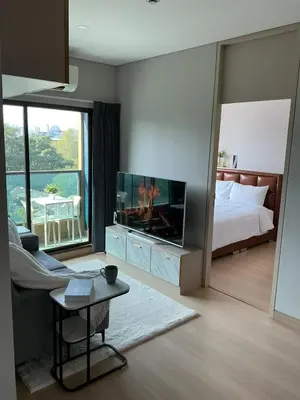 a living room with a television and a bed at 2BR Modern Condo Office Room Sofa Bed Pool Gym in Bangkok
