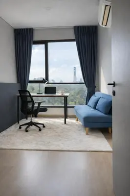 a living room with a blue couch and a desk at 2BR Modern Condo Office Room Sofa Bed Pool Gym in Bangkok