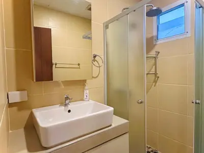 a bathroom with a sink and a glass shower at Cozy and Convenient Bangna House in Ban Khlong Samrong