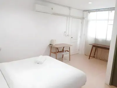 a white room with a bed and a table at XX Mitr Inn Sukhumvit Soi 2 - มิตร อินน์ สุขุมวิท ซอย 2 BTS Nana in Bang Kapi
