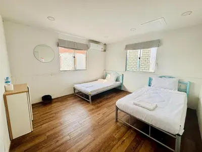 a hospital room with two beds and a mirror at BKK Rama3 Guest House in Bangkok