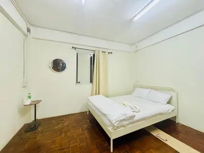 a bedroom with a white bed in a room at BKK Rama3 Guest House in Bangkok