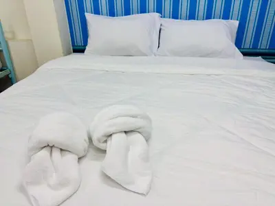 a bed with white towels and pillows on it at BKK Rama3 Guest House in Bangkok