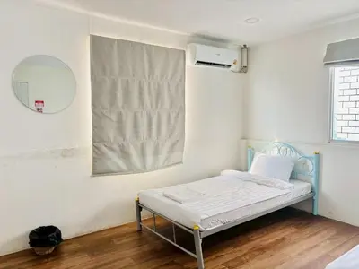 a small bed in a room with a mirror at BKK Rama3 Guest House in Bangkok
