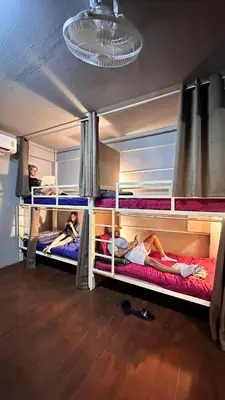 three people laying on bunk beds in a room at Y&D Hostel in Bangkok
