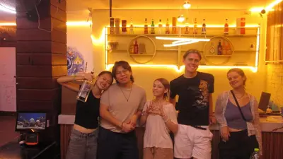 a group of people posing for a picture in a room at Y&D Hostel in Bangkok
