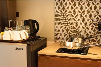 a kitchen with a stove with a pot on top of it at Tints of Blue Hotel in Bangkok