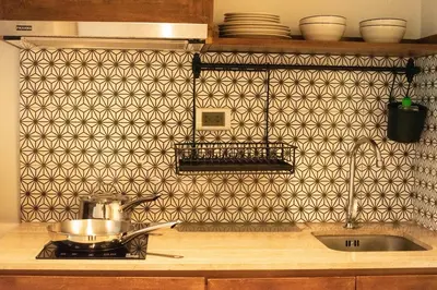 a kitchen with a pot on a stove with a patterned wall at Tints of Blue Hotel in Bangkok