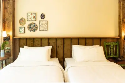 two beds sitting next to each other in a room at Tints of Blue Hotel in Bangkok
