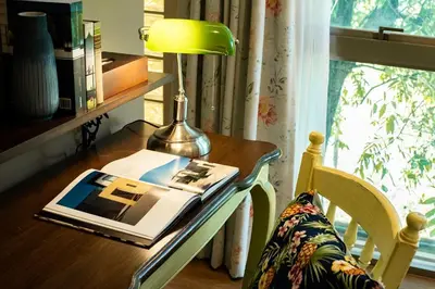 a desk with a lamp and a book on it at Tints of Blue Hotel in Bangkok