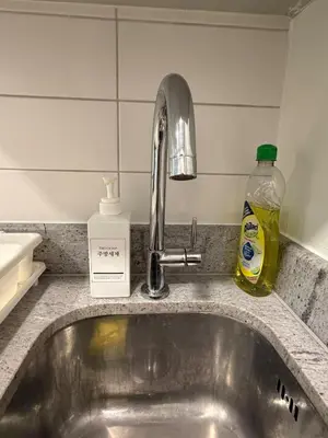 a kitchen counter with a sink and a soap bottle at Cozy Japandi Stay on Sukhumvit in Bangkok