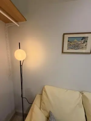 a living room with a couch and a lamp at Cozy Japandi Stay on Sukhumvit in Bangkok