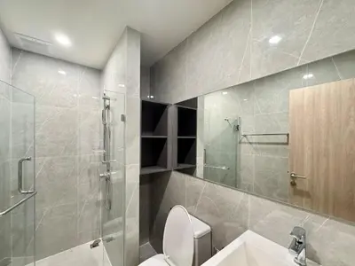 a bathroom with a toilet and a glass shower at Spacious 2 Bedrooms at MRT Rama 9 and Central R9 in Bangkok