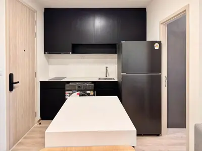a kitchen with a white table and a refrigerator at Spacious 2 Bedrooms at MRT Rama 9 and Central R9 in Bangkok
