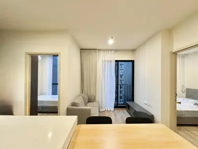 a living room with a table and a bedroom at Spacious 2 Bedrooms at MRT Rama 9 and Central R9 in Bangkok