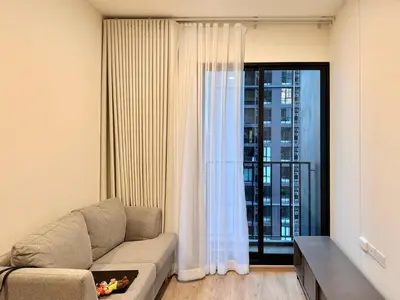 a living room with a couch and a large window at Spacious 2 Bedrooms at MRT Rama 9 and Central R9 in Bangkok