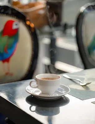 a cup of coffee sitting on top of a table at Hotel Clover Asoke - SHA Extra Plus in Bangkok