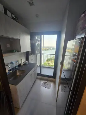 a kitchen with a sink and a view of a balcony at The Politan Aqua in Ban Sai Ma