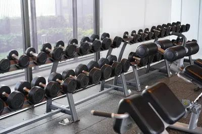 a row of rows of dumbbells in a gym at The Politan Aqua in Ban Sai Ma