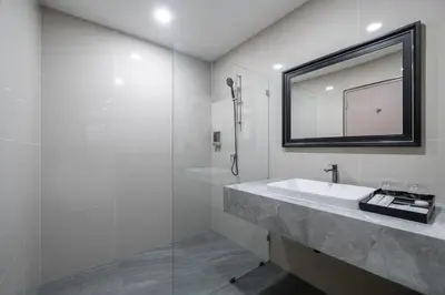 a white bathroom with a sink and a mirror at SureStay Plus by Best Western Ramkhamhaeng Airport Rail Link Bangkok in Bangkok