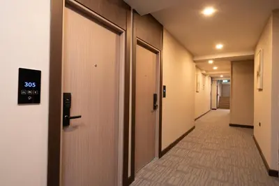 a hallway with doors and a tile floor at SureStay Plus by Best Western Ramkhamhaeng Airport Rail Link Bangkok in Bangkok
