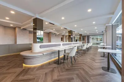 a restaurant with a bar with tables and chairs at SureStay Plus by Best Western Ramkhamhaeng Airport Rail Link Bangkok in Bangkok