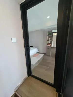 a view of a room with a bed through a mirror at New Ultra Highend Condo center BKK BTS 4min walk Perfect for Staycation in Bangkok