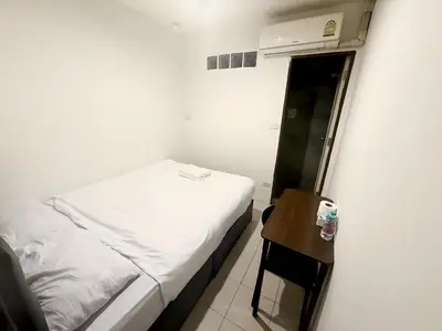 a small bedroom with a bed and a small table at xx zNap Khaosan - แสนป ข้าวสาร รามบุตรี in Bang Bua Thong Railway Station