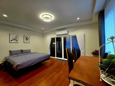 a bedroom with a bed and a table and a dining room at The Atlas hostel Bangkok in Thung Si Kan