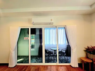 a room with a glass door with a table and chairs at The Atlas hostel Bangkok in Thung Si Kan