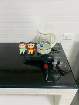 a table with a cup and two figurines on it at Pixie Happy Room Popular Condo C5 Cozy Private Room near IMPACT Muangthong in Ban Bang Phang